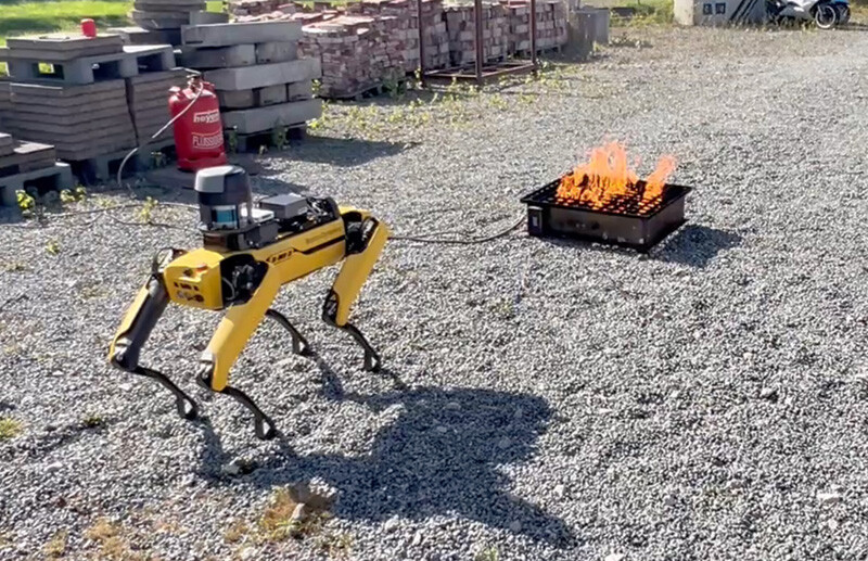 Experimental setup: a Boston Dynamics Spot robot approaching a controlled propane fire, equipped with depth and thermal sensors.